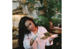 Image A woman looks at herbs on a glass plate.
